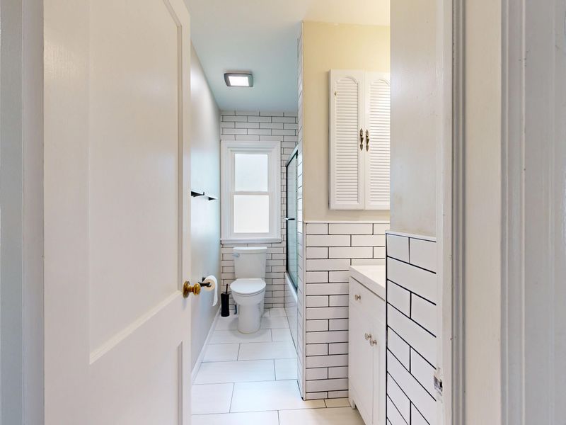 Bright modern white bathroom featuring subway tiles and minimalist design.
