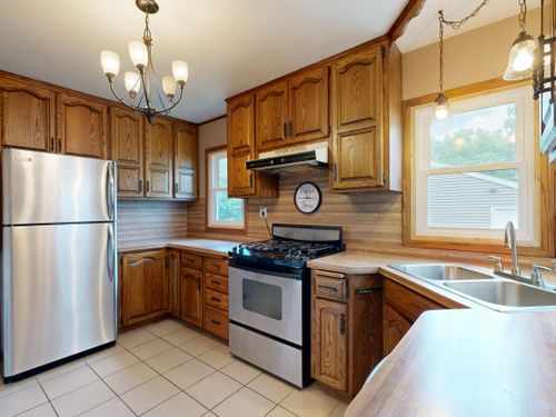 Free Cozy kitchen interior featuring wooden cabinets and stainless steel appliances for a homely atmosphere. Stock Photo