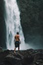 一名男子在巴厘岛乌布的瀑布旁，拥抱冒险与自然