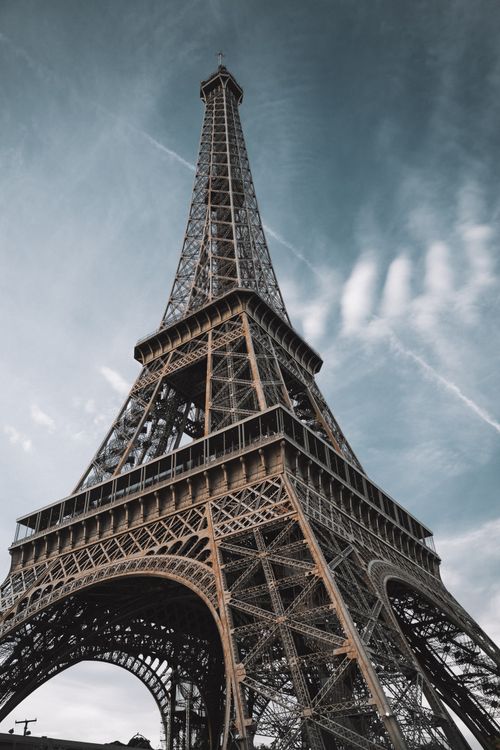 Free A breathtaking low-angle photograph of the Eiffel Tower under a dramatic sky. Stock Photo
