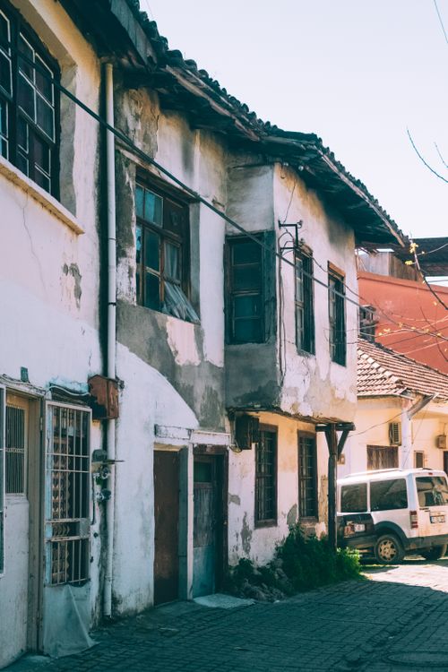 Free Charming vintage residential street showcasing aged architecture with a parked vehicle. Stock Photo