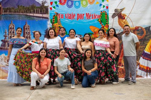 Free A group of people in traditional Mexican attire posing in front of a cultural backdrop. Stock Photo