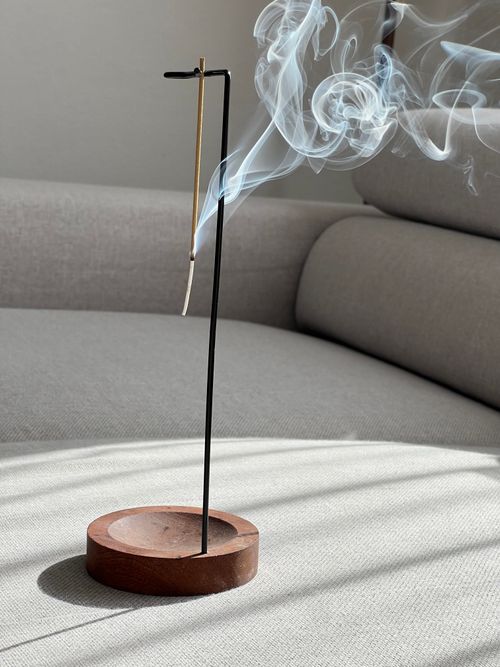 Free Minimalist incense holder emitting spiraling smoke in a cozy setting, ideal for relaxation and meditation themes. Stock Photo