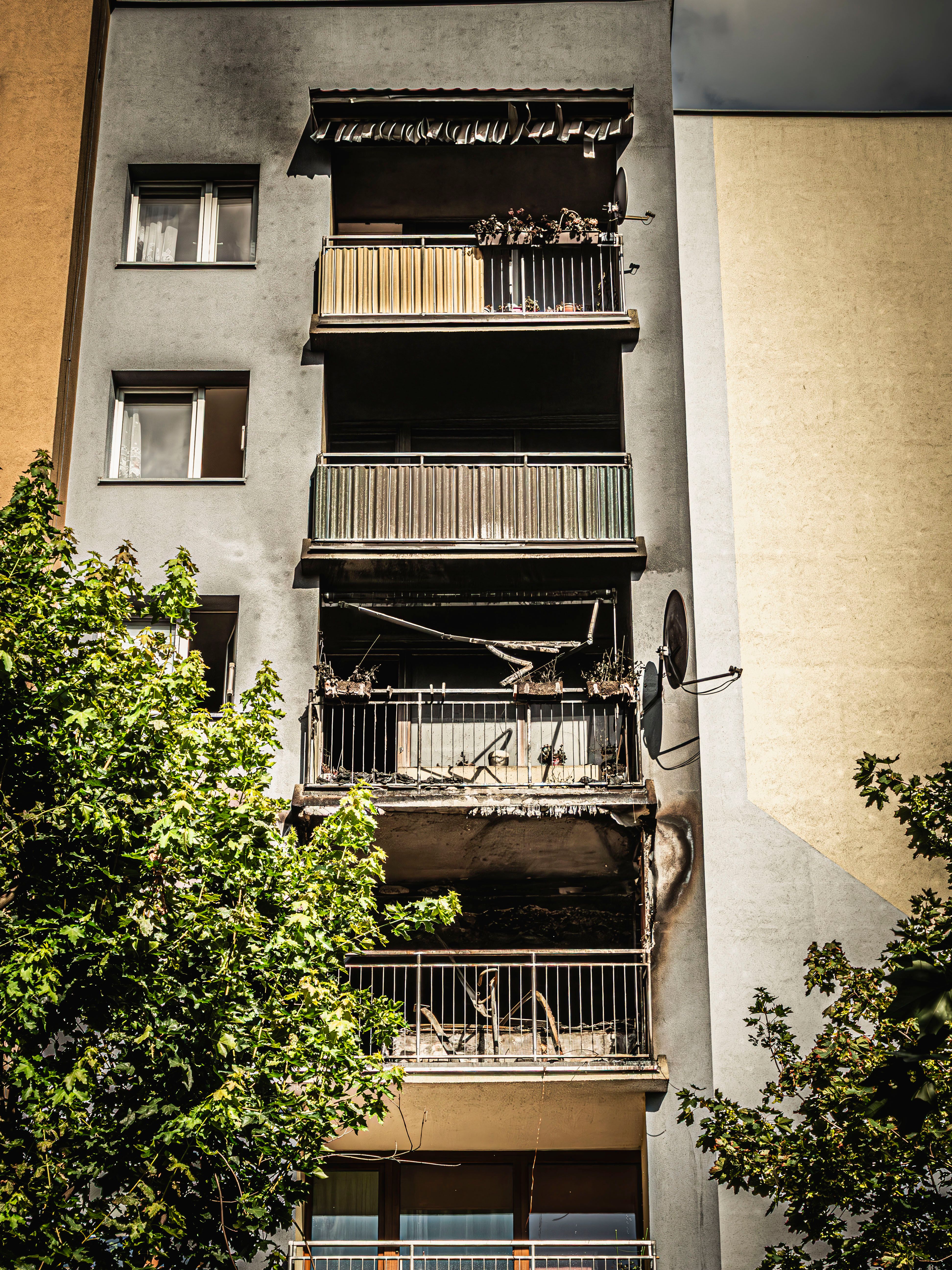 Façade d'immeuble d'habitation dont plusieurs balcons portent les traces noircies d'un incendie.