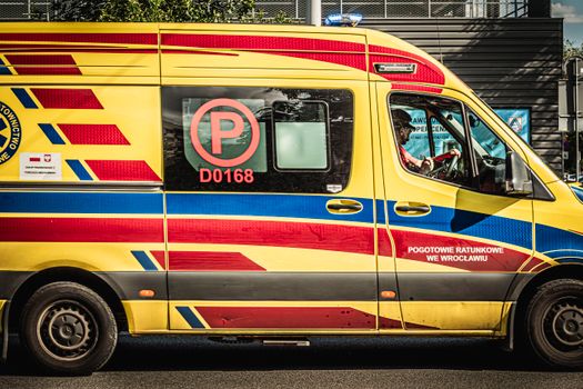 Yellow and red ambulance in Wrocław, Poland photographed during the day.