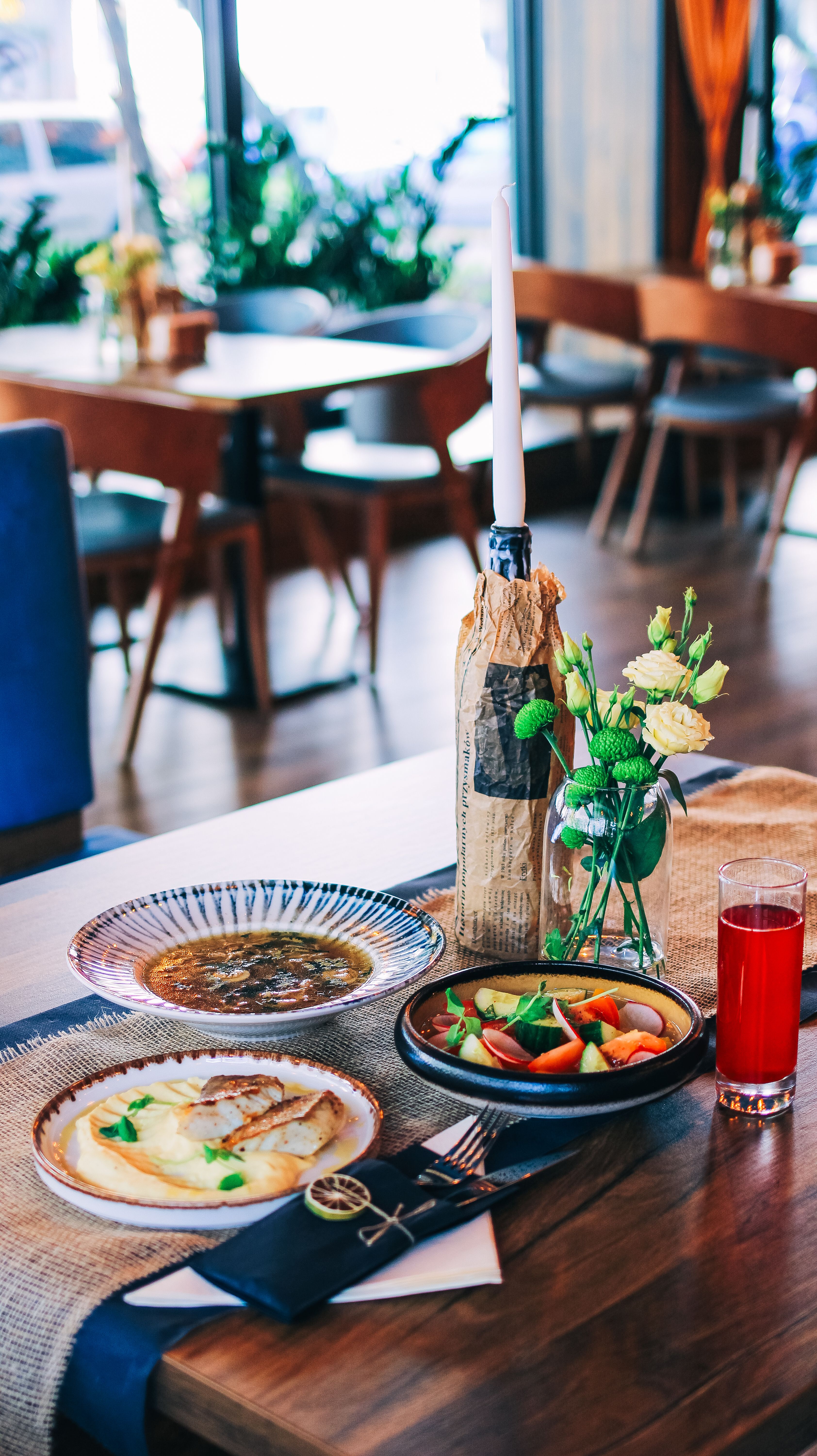 A beautifully arranged restaurant table with elegant dishes, floral decor, and ambient lighting, perfect for dining inspiration.