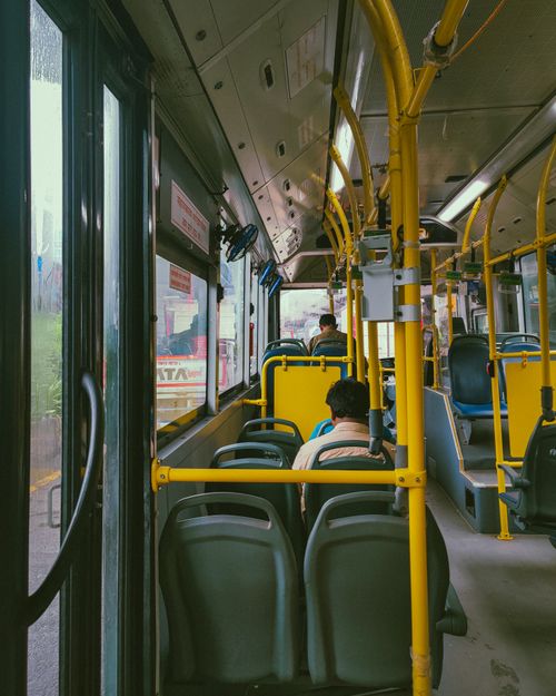 Free View from inside a Mumbai public bus, featuring passengers and urban scenery through windows. Stock Photo
