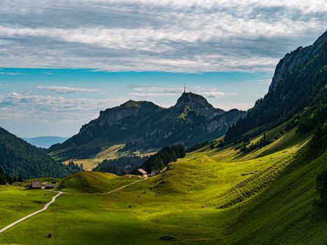 Breathtaking view of lush green valleys and mountains in Sennwald, Switzerland.