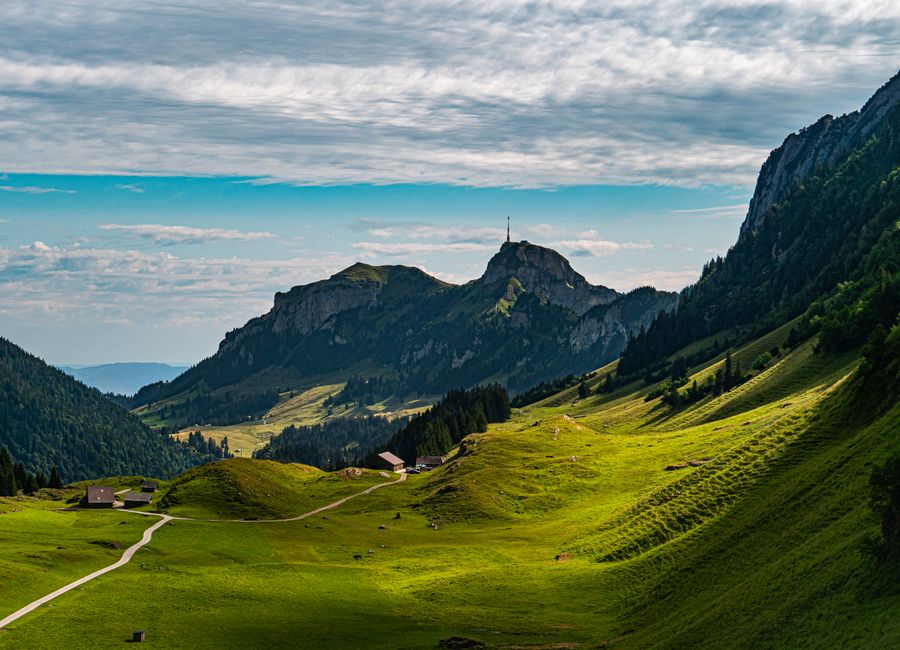 Breathtaking view of lush green valleys and mountains in Sennwald, Switzerland.