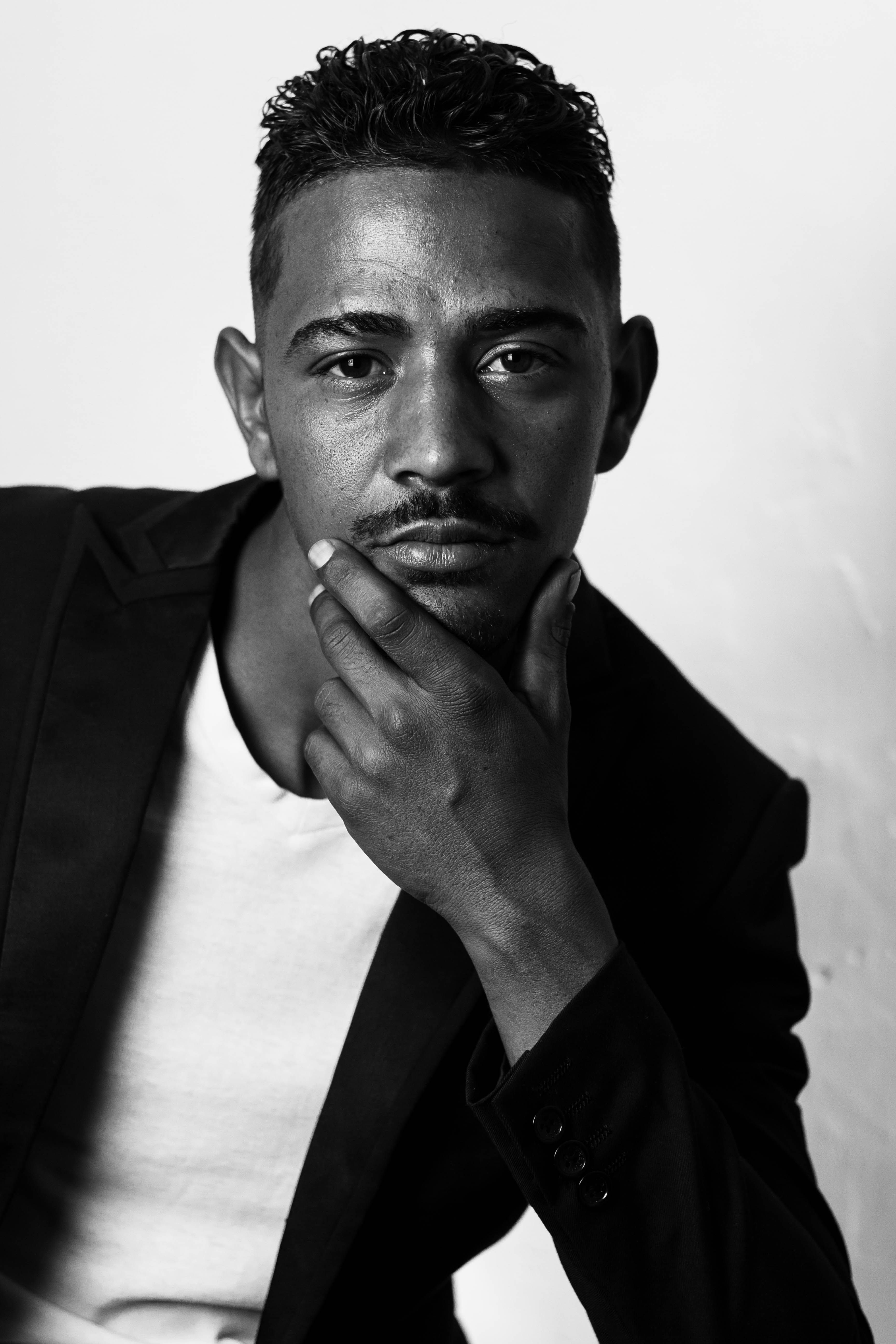 Monochrome close-up portrait of a thoughtful man in South Africa posing with hand on chin.