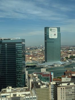 Aerial view of modern skyscrapers dominating the skyline of Milan, Italy, on a sunny day.