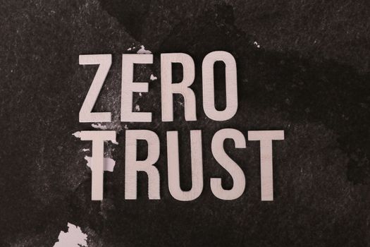 Wooden text reading 'Zero Trust' on a black textured background emphasizing security.