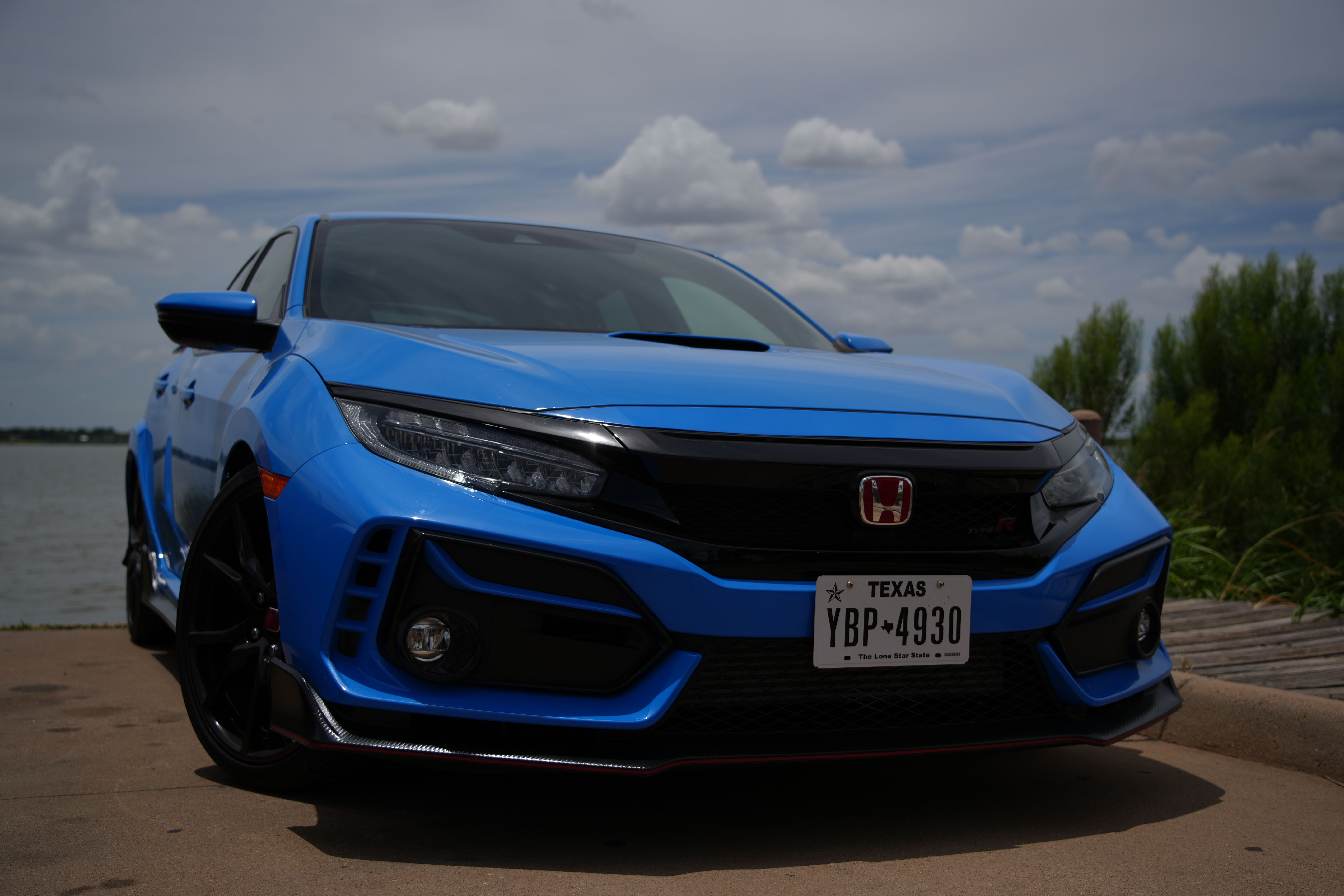 A striking blue Honda Civic Type R parked by a scenic lake in Wichita Falls, Texas.