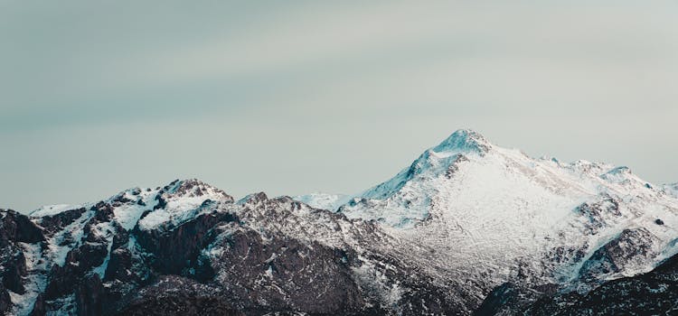Panoramic view of rocky ridge of mountains covered with snow in winter day