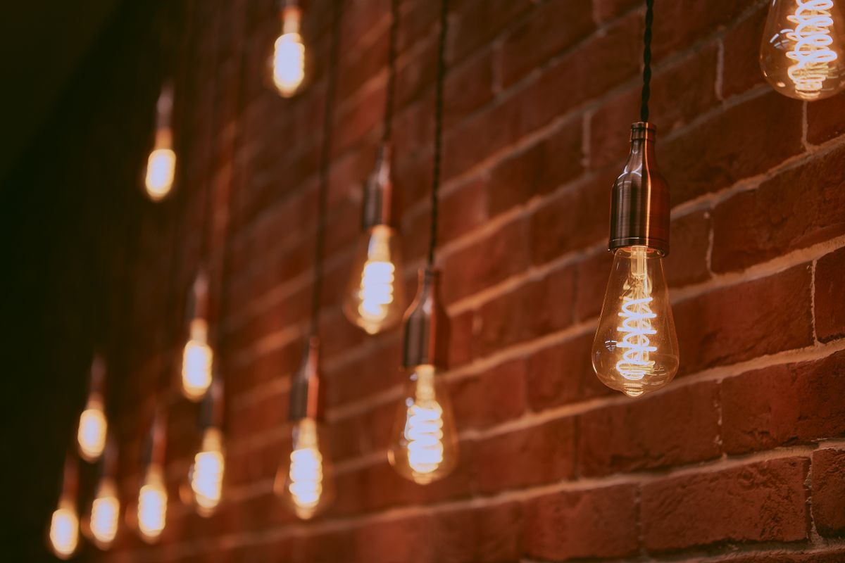 Warm Edison-style pendant bulbs hanging against an exposed brick wall