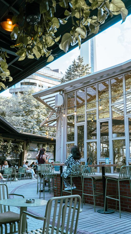 Free A vibrant outdoor cafe scene in Ankara, featuring modern design with people enjoying a sunny day. Stock Photo