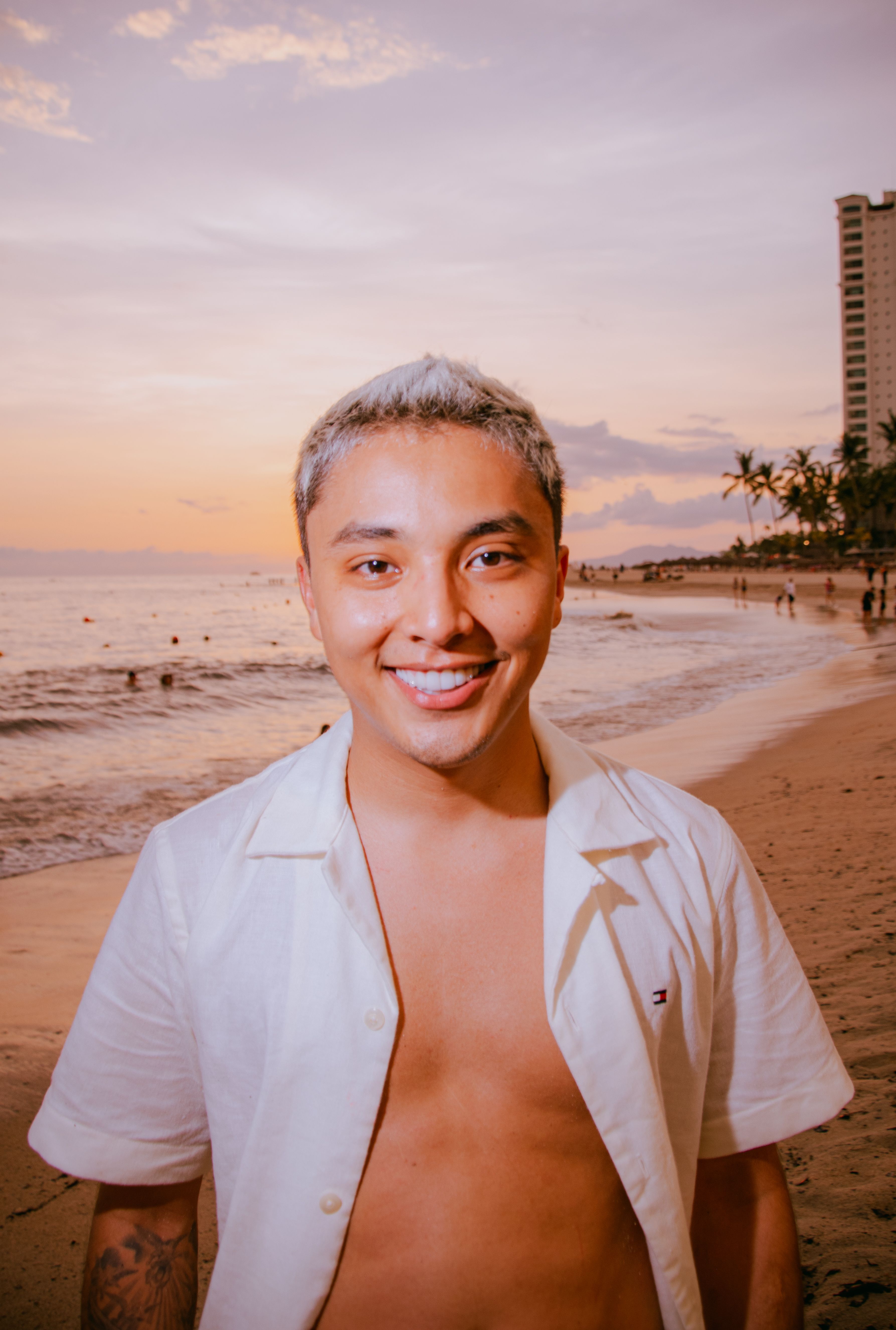 Young man in casual attire enjoying a sunset on the beach in Puerto Vallarta, Mexico.