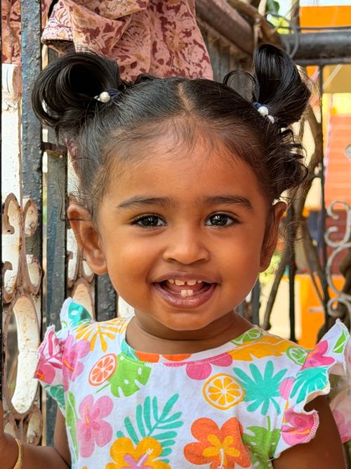 Free Adorable South Asian child smiling brightly outdoors in colorful attire. Stock Photo