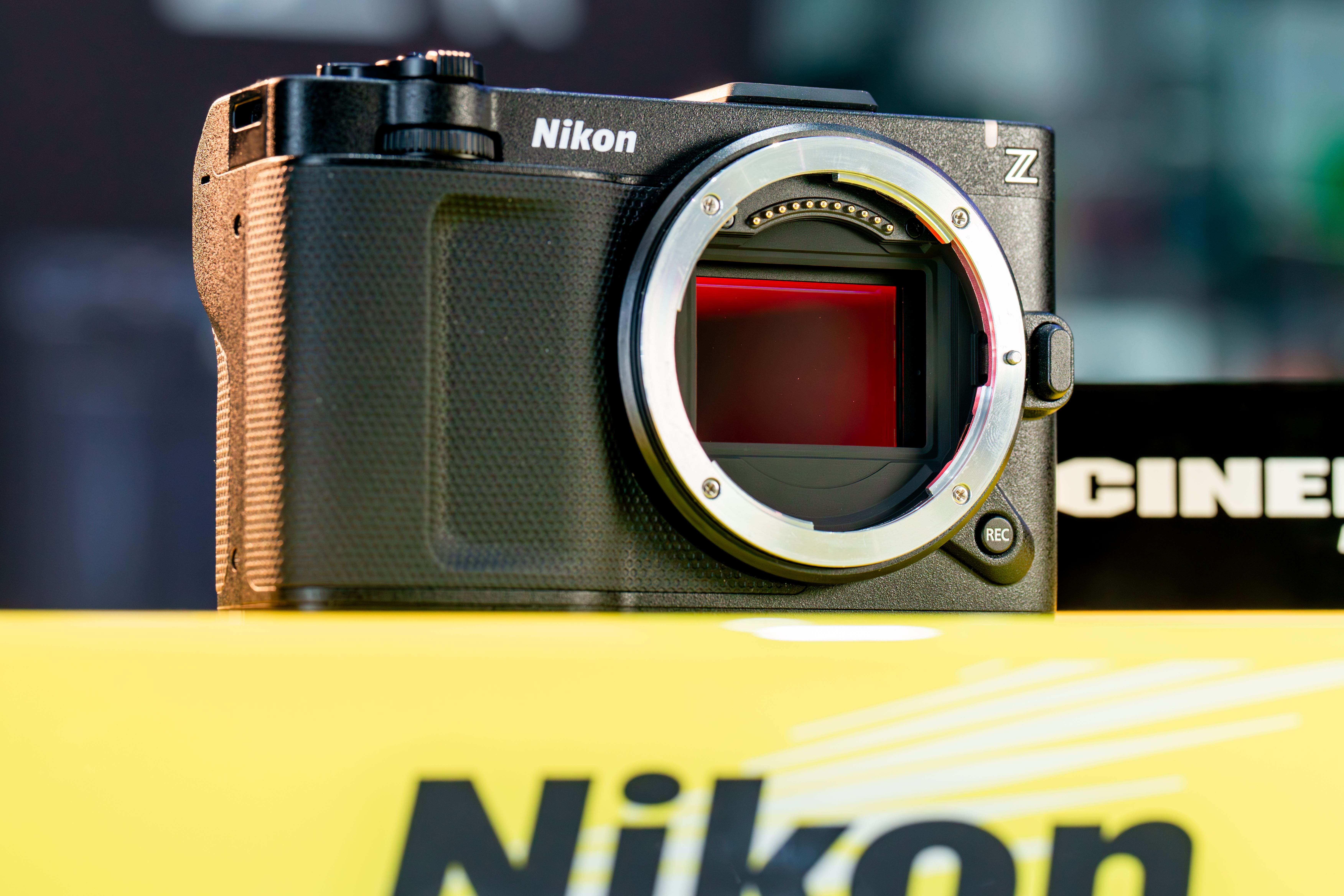 Detailed image of a Nikon mirrorless camera body on a yellow background.