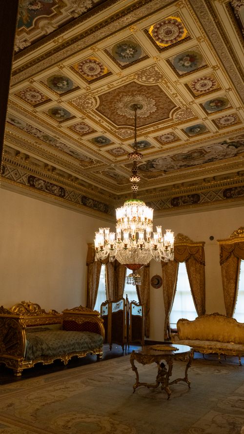Free Elegant vintage room with ornate ceiling and chandelier, showcasing classic luxurious decor. Stock Photo
