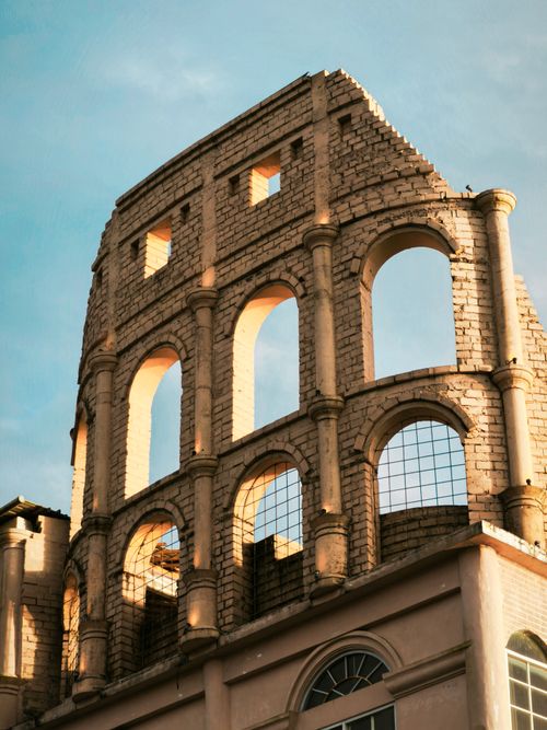 Free Close-up view of a building facade inspired by the Roman Colosseum, showcasing arches and stone details. Stock Photo