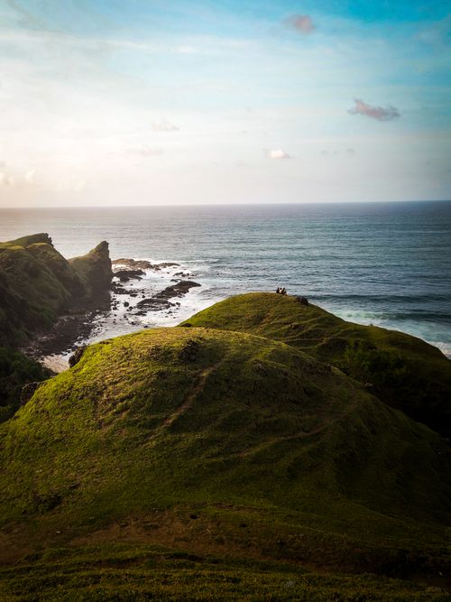 Free Stunning view of green cliffs and ocean at sunset, capturing the beauty of nature. Stock Photo