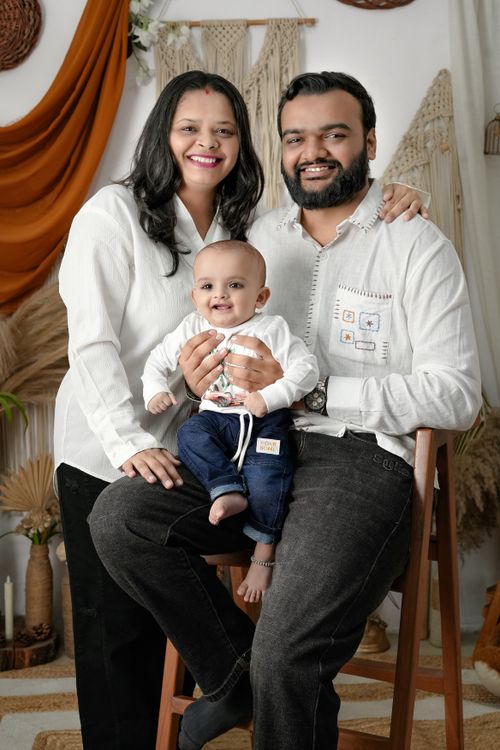 Free Happy family with a baby poses in a warmly decorated room with rustic elements. Stock Photo