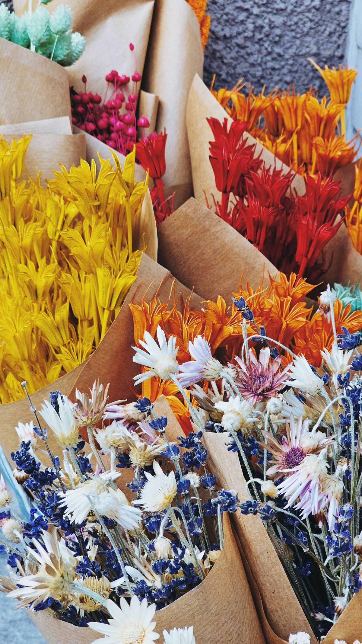 Colorful dried flower bouquets wrapped in brown paper