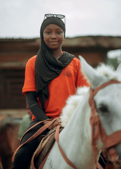 Free A young girl in traditional attire riding a white horse outdoors, reflecting cultural heritage. Stock Photo