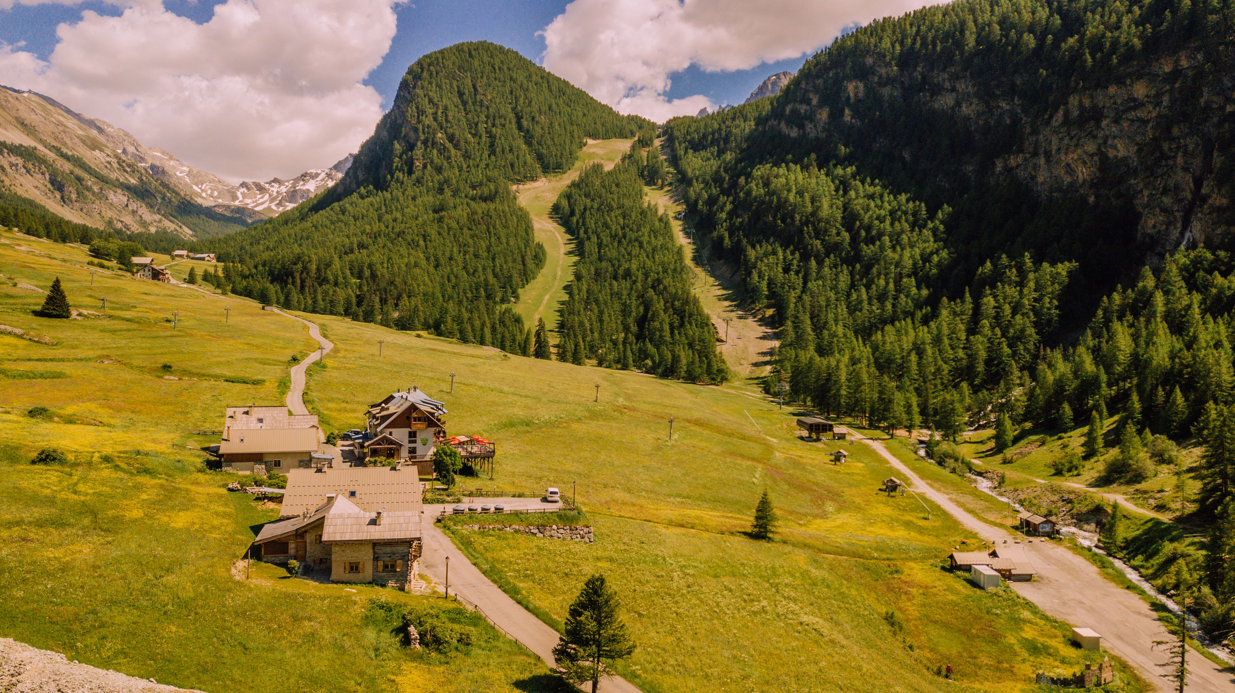 Idyllic mountain village scene with lush greenery and clear skies, perfect for summer travel inspiration.