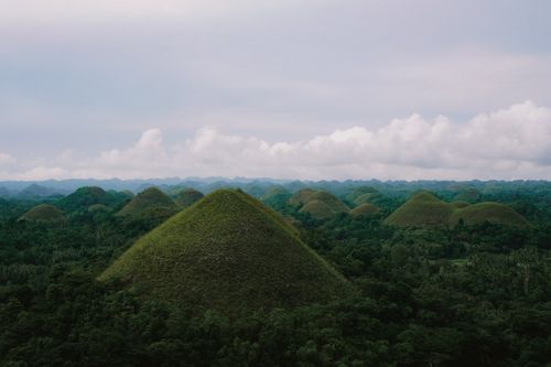 Free Breathtaking aerial perspective of the iconic Chocolate Hills in Bohol, Philippines under a vast sky. Stock Photo