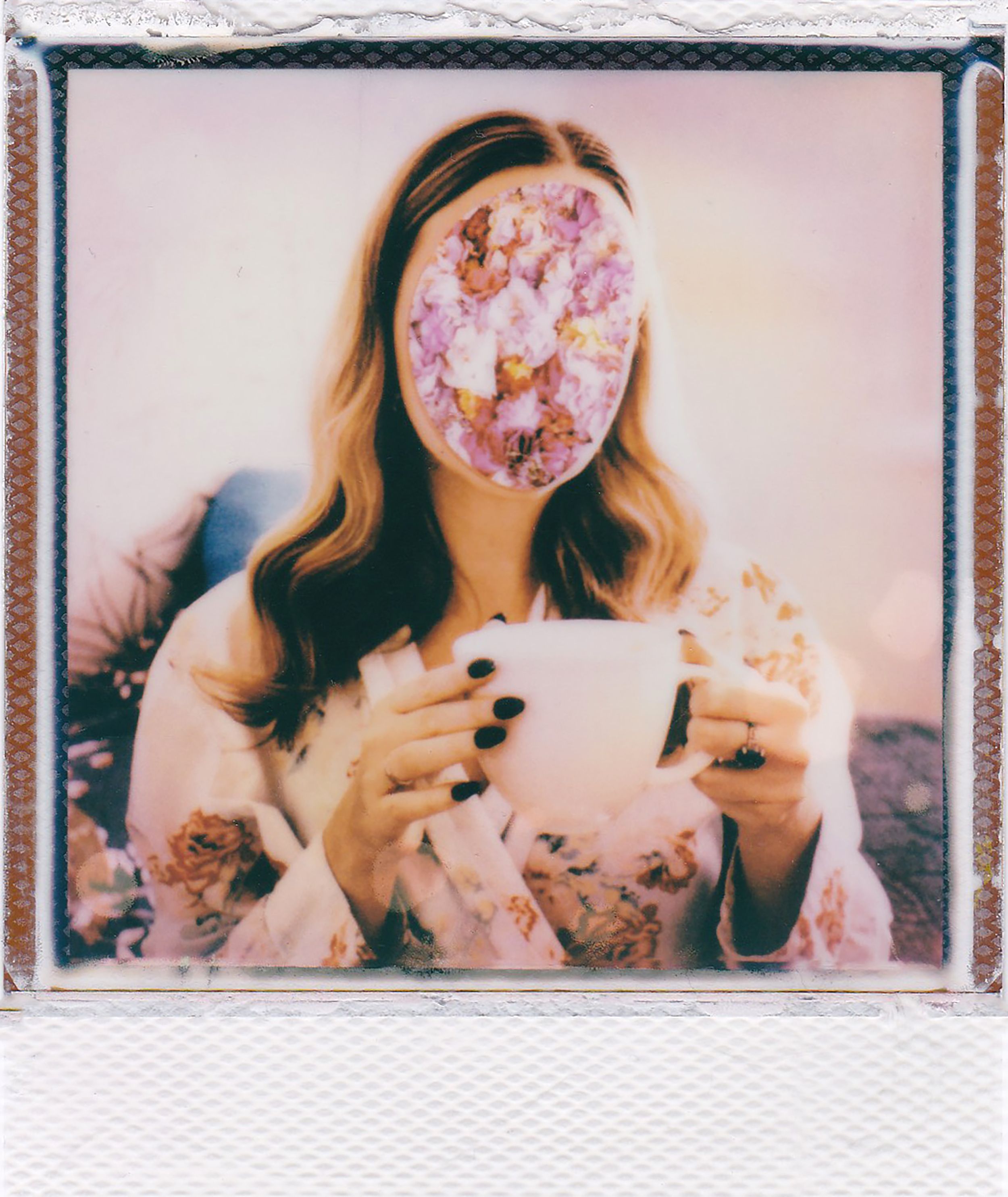 An artistic photo of a woman with a floral arrangement as her face, holding a mug.