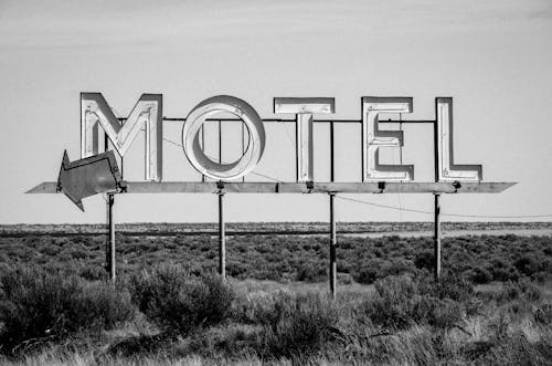Grayscale Photo of Motel Signage