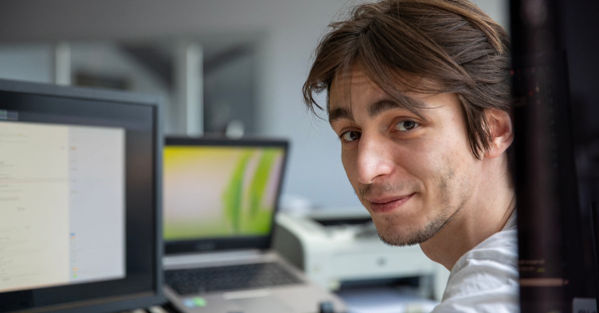 Un joven profesional trabajando en su escritorio en un entorno de oficina contemporáneo.