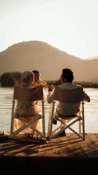 A family enjoys a peaceful sunset by the lake, reflecting warmth and togetherness.