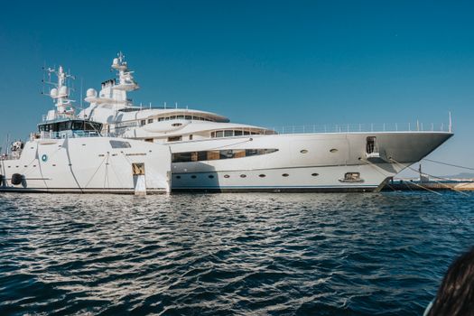 A majestic luxury yacht docked on serene waters under a clear blue sky, exemplifying nautical elegance.