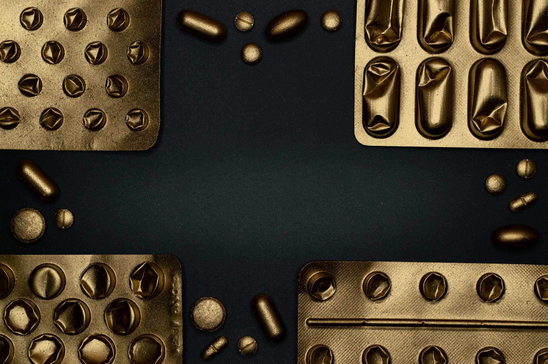 Gold Blister Packs on Black Surface