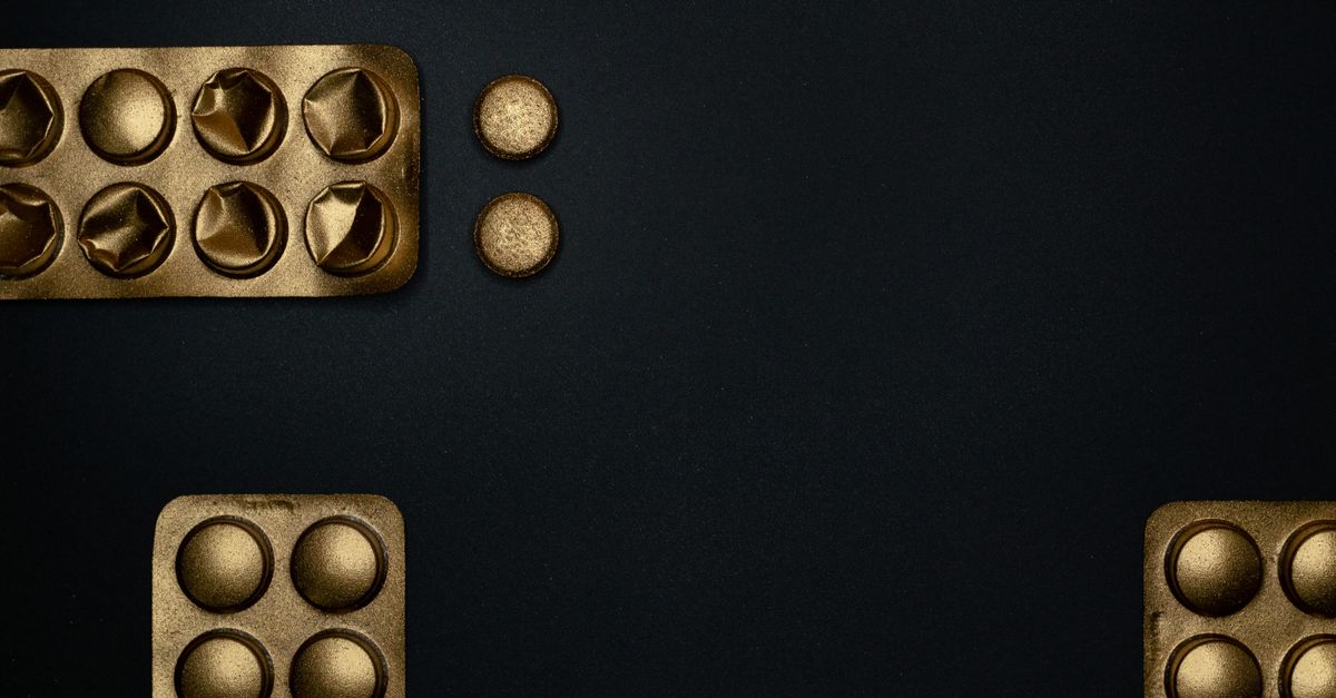 Tablets and blister packs on a black surface
