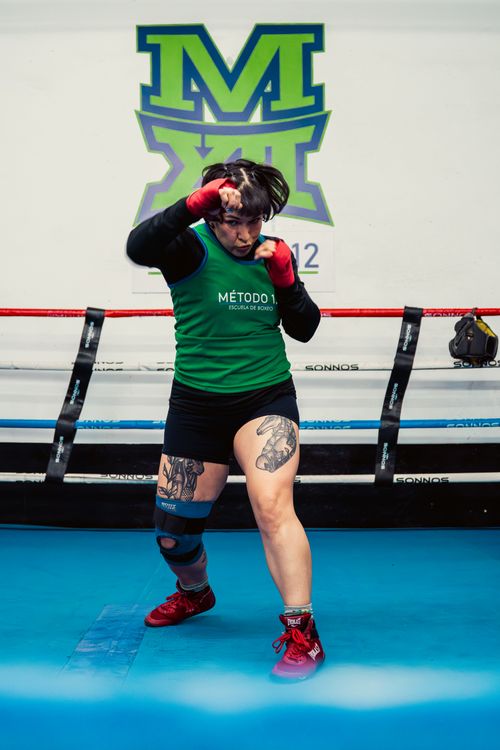 Free Focused female boxer practicing in a vibrant Buenos Aires gym, showcasing strength and dedication. Stock Photo