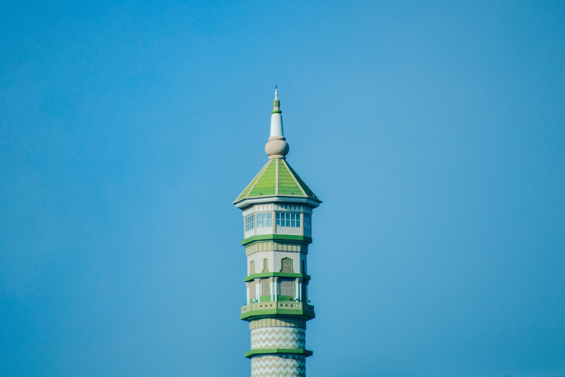 A stunning mosque tower set against a clear blue sky in Lampung, Indonesia.