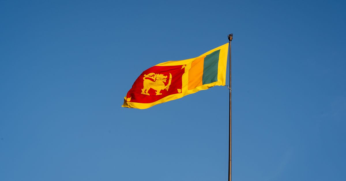 The national flag of Sri Lanka waving proudly against a clear blue sky in Colombo.