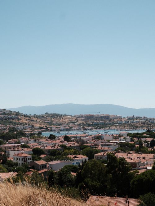 Free Discover the breathtaking landscape of İzmir's coastal town featuring red-roofed houses and lush greenery. Stock Photo