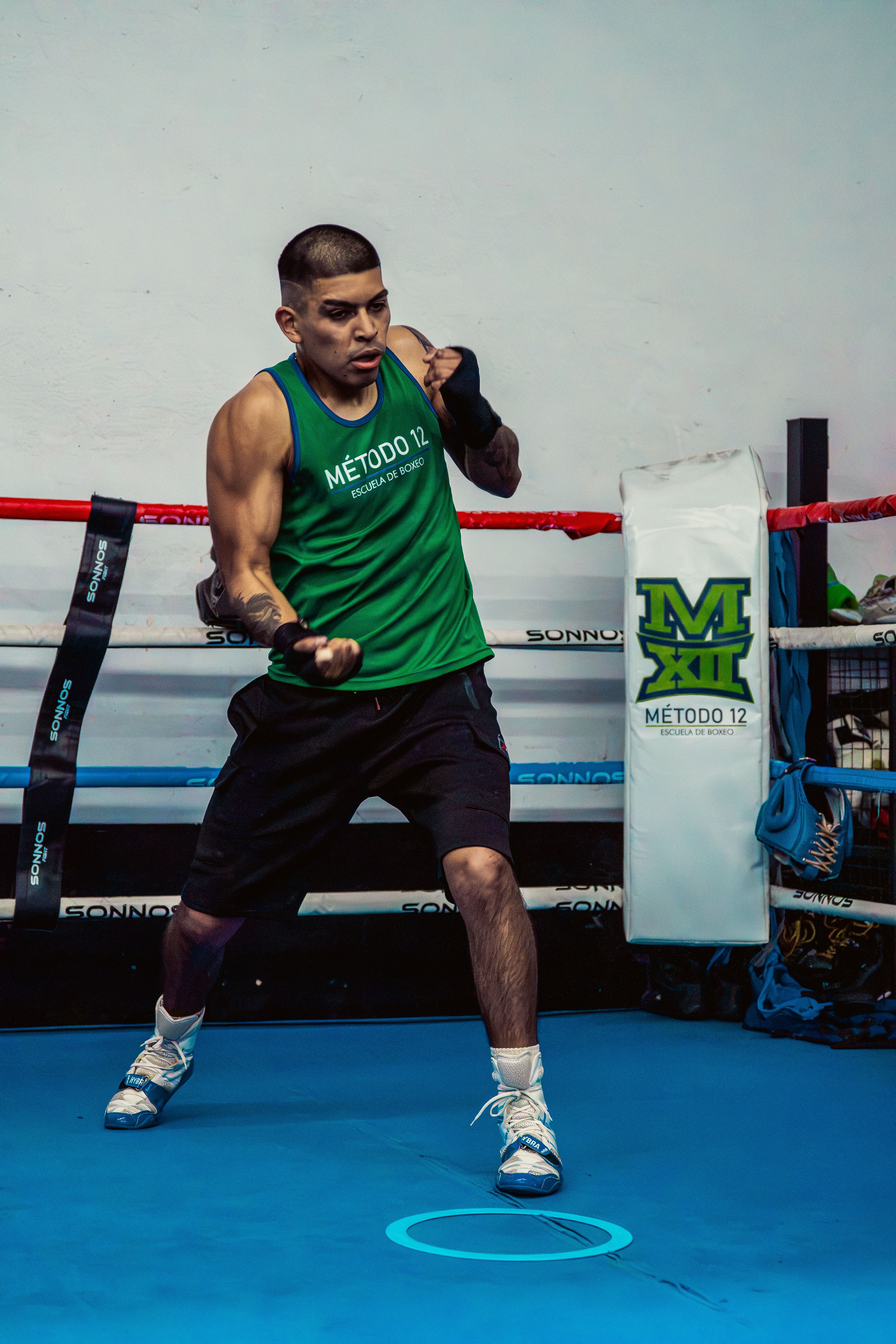 A male boxer in a gym executing a training drill, showcasing focus and athleticism.