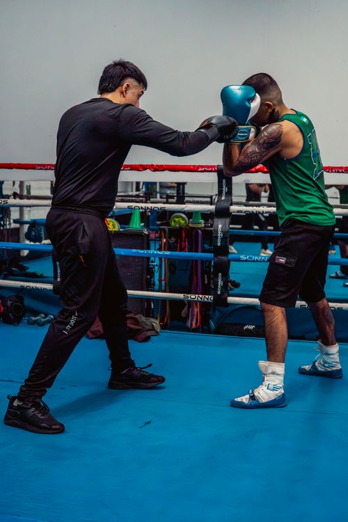 Free Two men sparring in a boxing gym, focusing on technique and precision training. Stock Photo