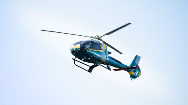 Colorful helicopter in flight over Niagara Falls, Ontario, Canada.
