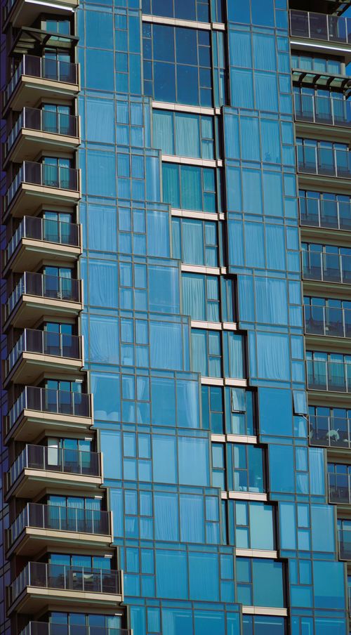 Free Bright glass windows of a skyscraper reflecting sunlight in an urban environment. Stock Photo