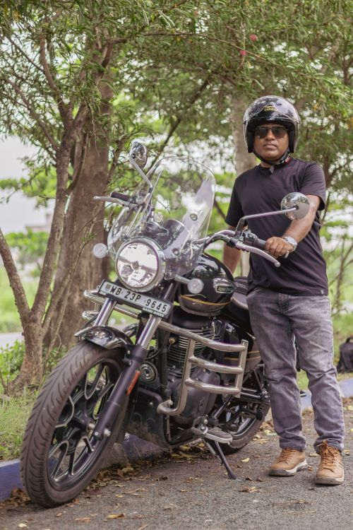Free Man posing with motorcycle in a park in Kolkata, India. Stock Photo