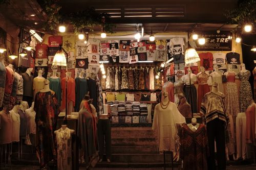 Free Vibrant clothing display at a Vietnamese night market featuring various dresses, shirts, and mannequins. Stock Photo