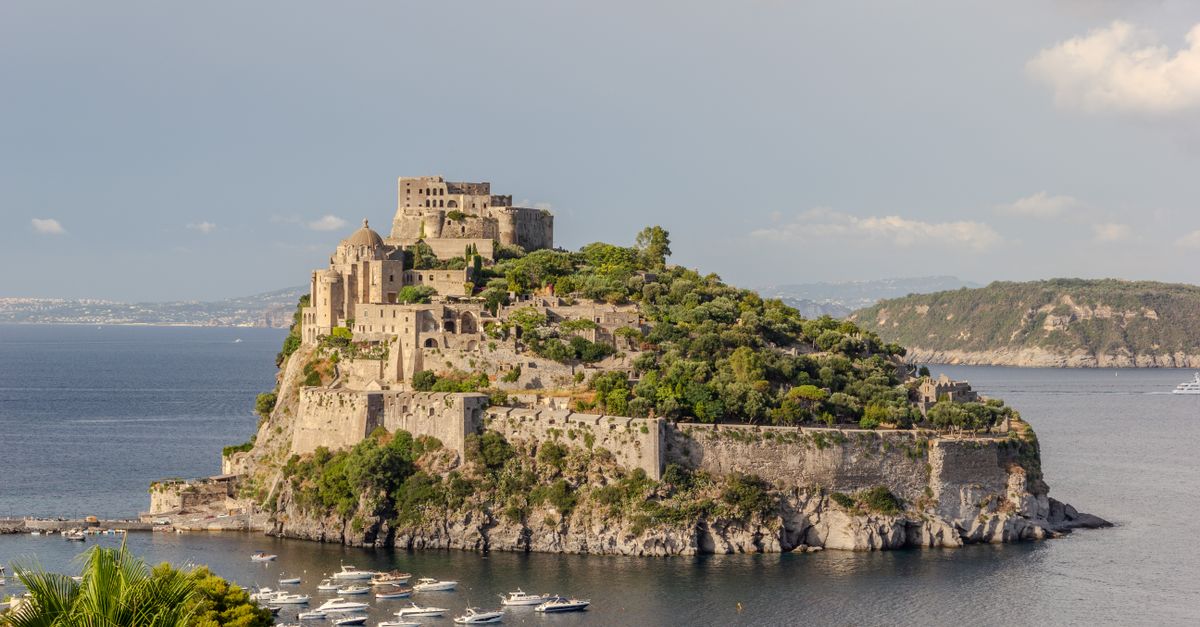 A stunning view of the historic Aragonese Castle on Ischia Island in Italy, surrounded by the sea.