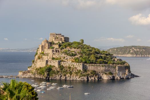 A stunning view of the historic Aragonese Castle on Ischia Island in Italy, surrounded by the sea.